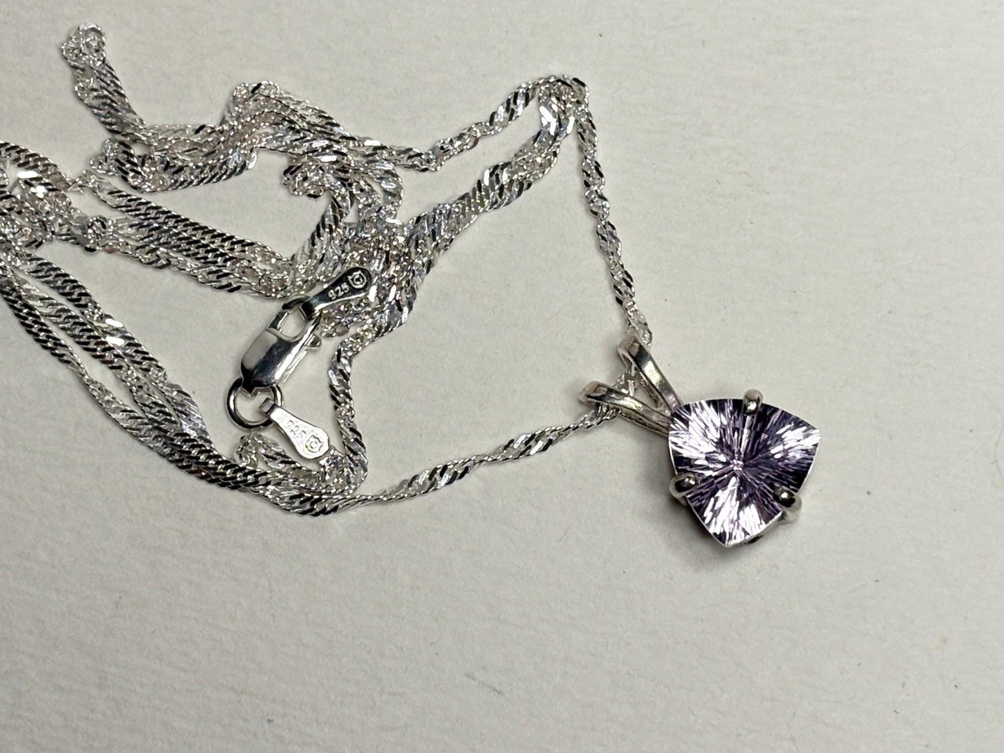 Sterling silver necklace with a trillion-cut kunzite pendant.