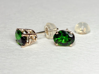 14k gold stud earrings with 5x7mm oval chrome diopside gemstones and silicone backs.