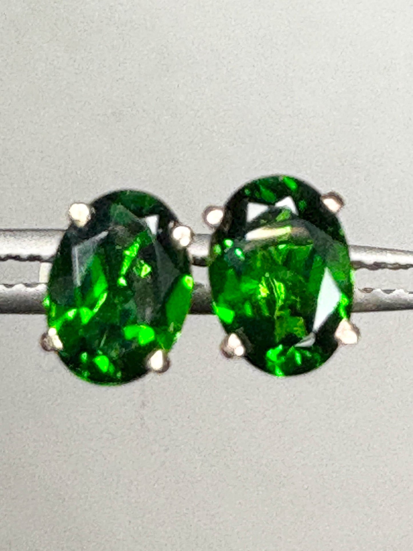 Pair of oval chrome diopside stud earrings in 14k gold.