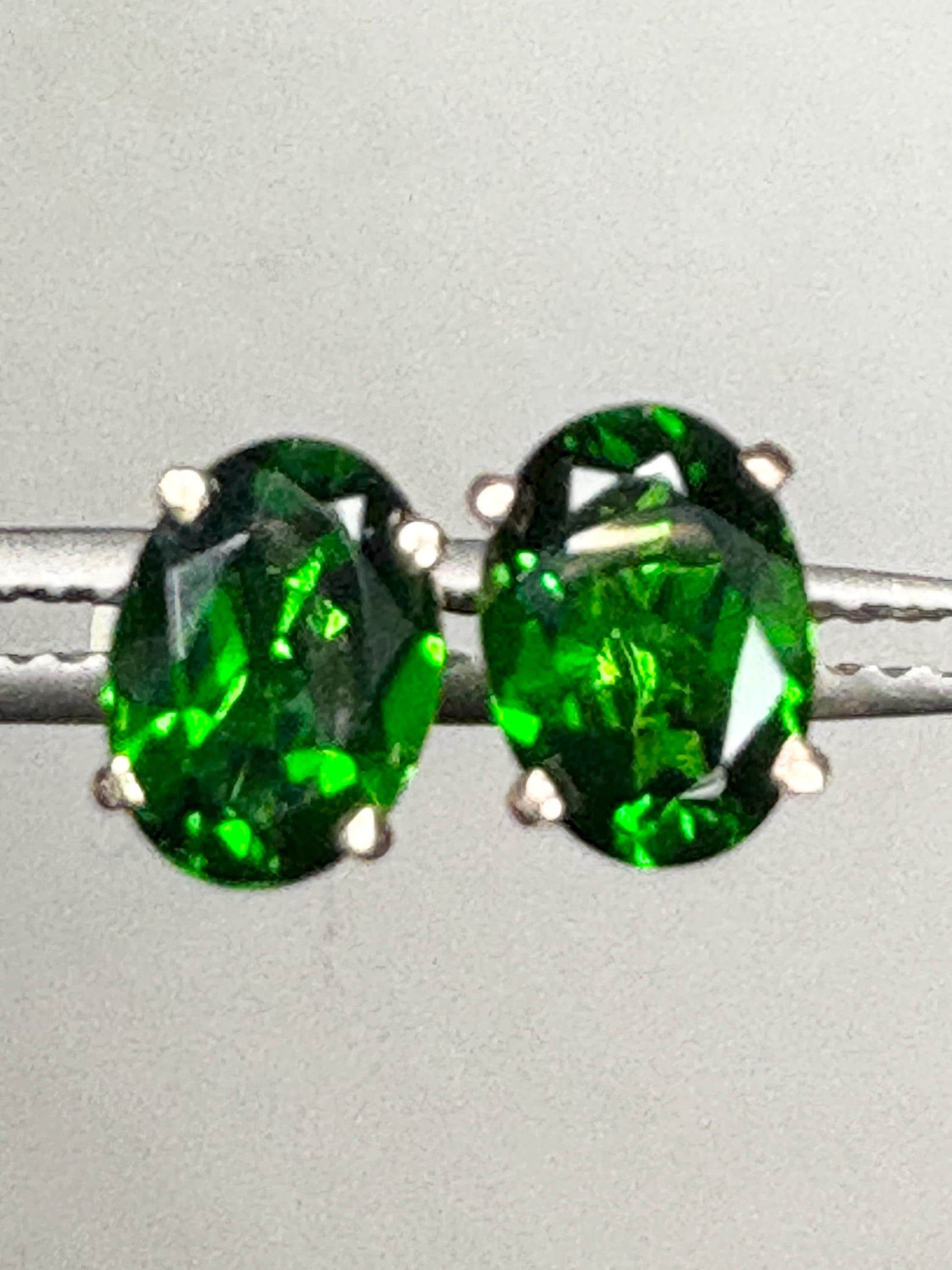 Pair of oval chrome diopside stud earrings in 14k gold.