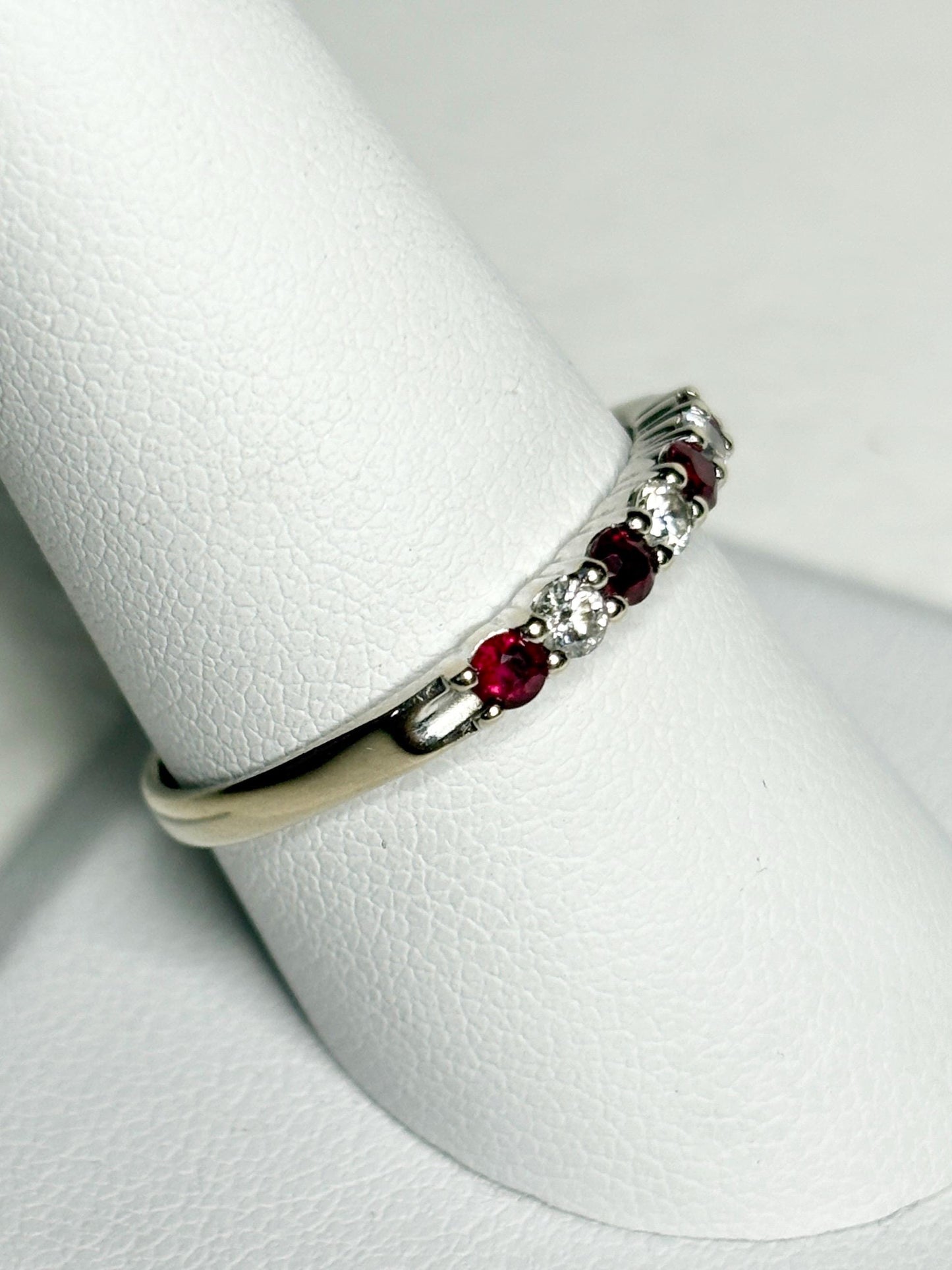 A white gold band ring with alternating rubies and diamonds.