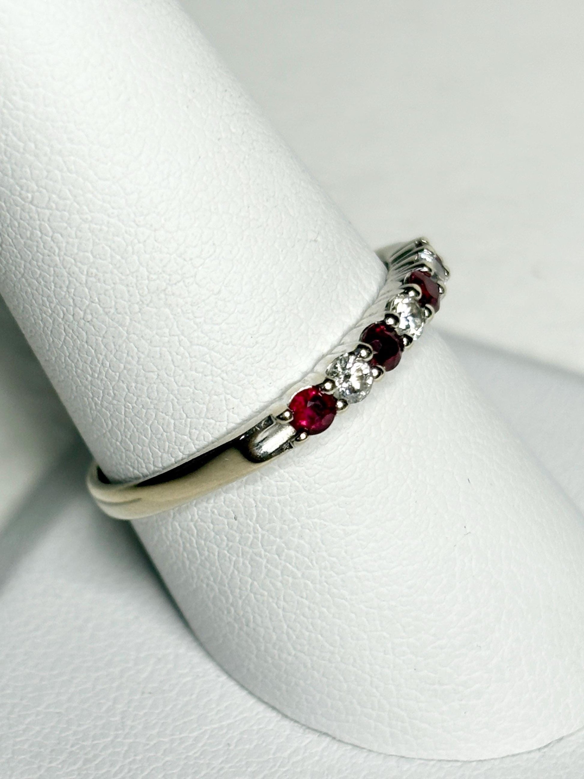A white gold band ring with alternating rubies and diamonds.