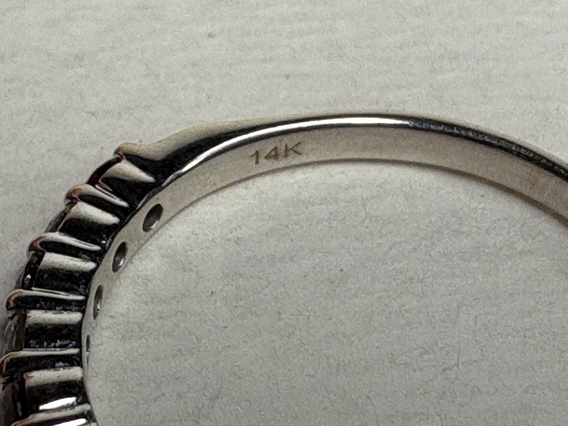 A 14k white gold band ring with rubies and diamonds.