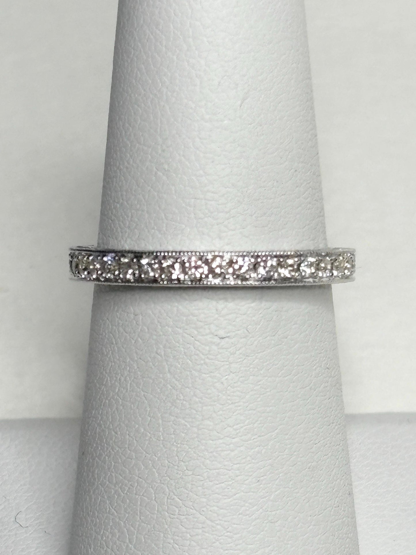 A 14k white gold stackable band ring with .56 ctw diamonds and detailed etching.