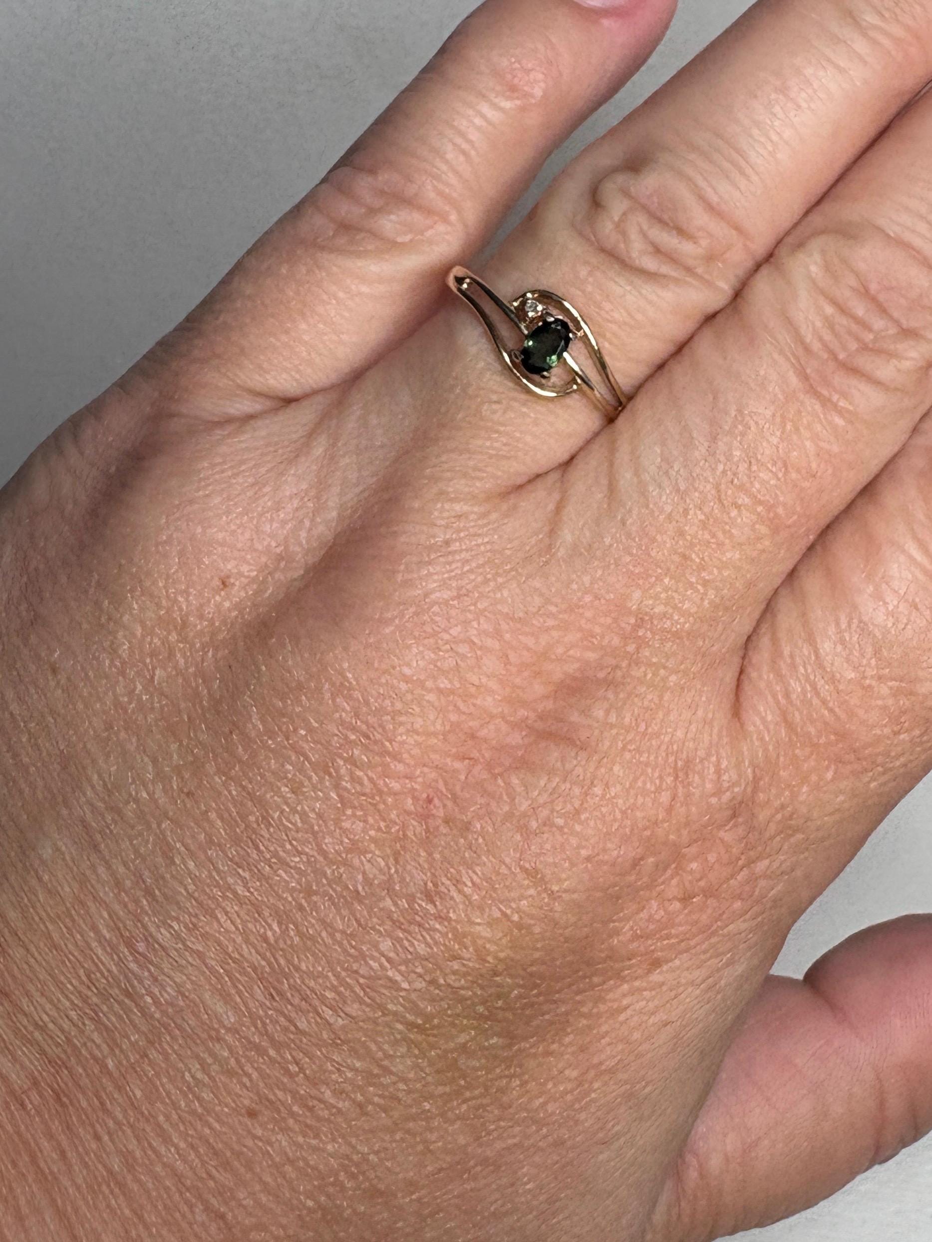 10k gold ring with green tourmaline and diamond accent.