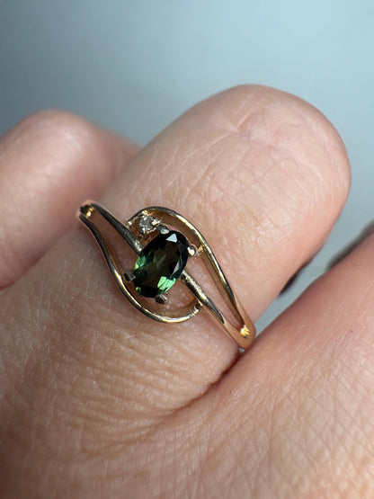 A 10k gold ring with an oval green tourmaline and a small diamond accent.