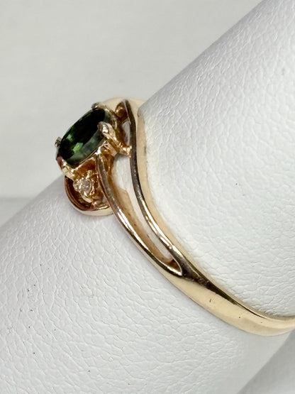 10k yellow gold ring with an oval green tourmaline and diamond accent.