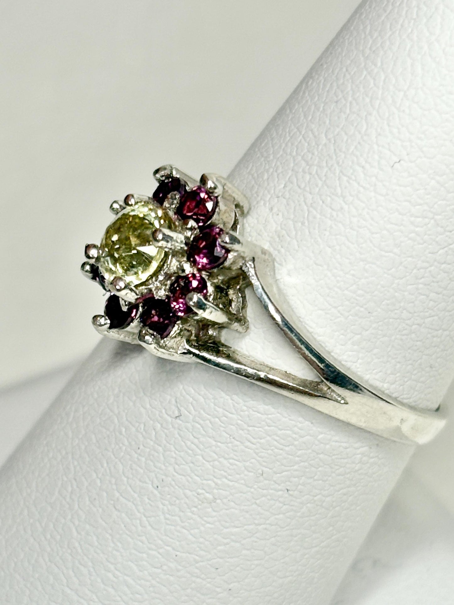Sterling silver ring with a central yellow garnet surrounded by rhodolite garnets.