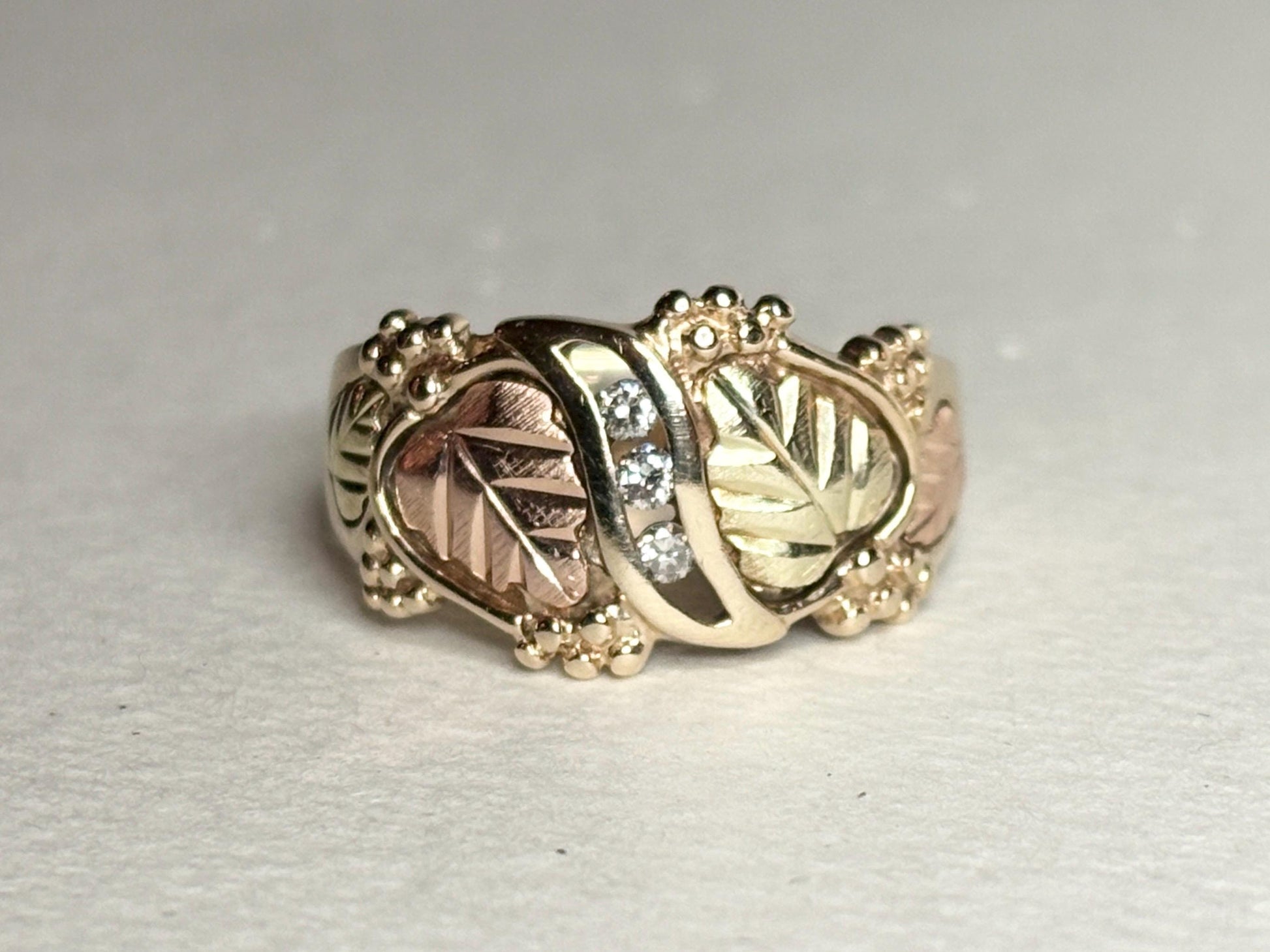 Black Hills Gold ring with diamonds and tri-color gold leaves.