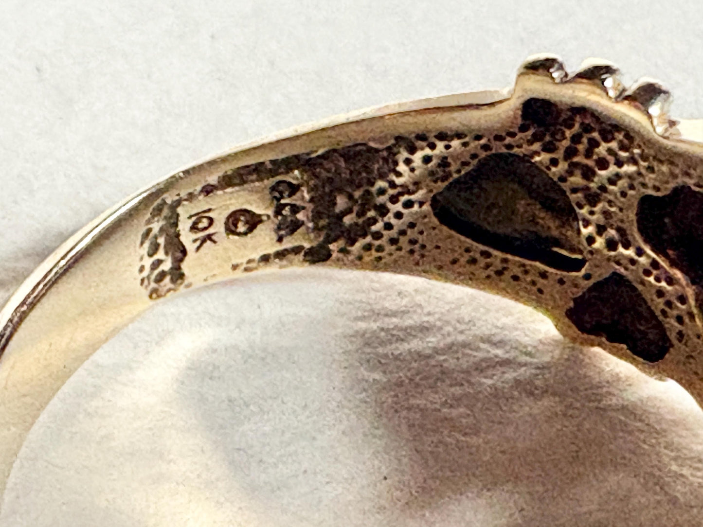 A 10k tri-color gold ring with diamonds and a textured band.