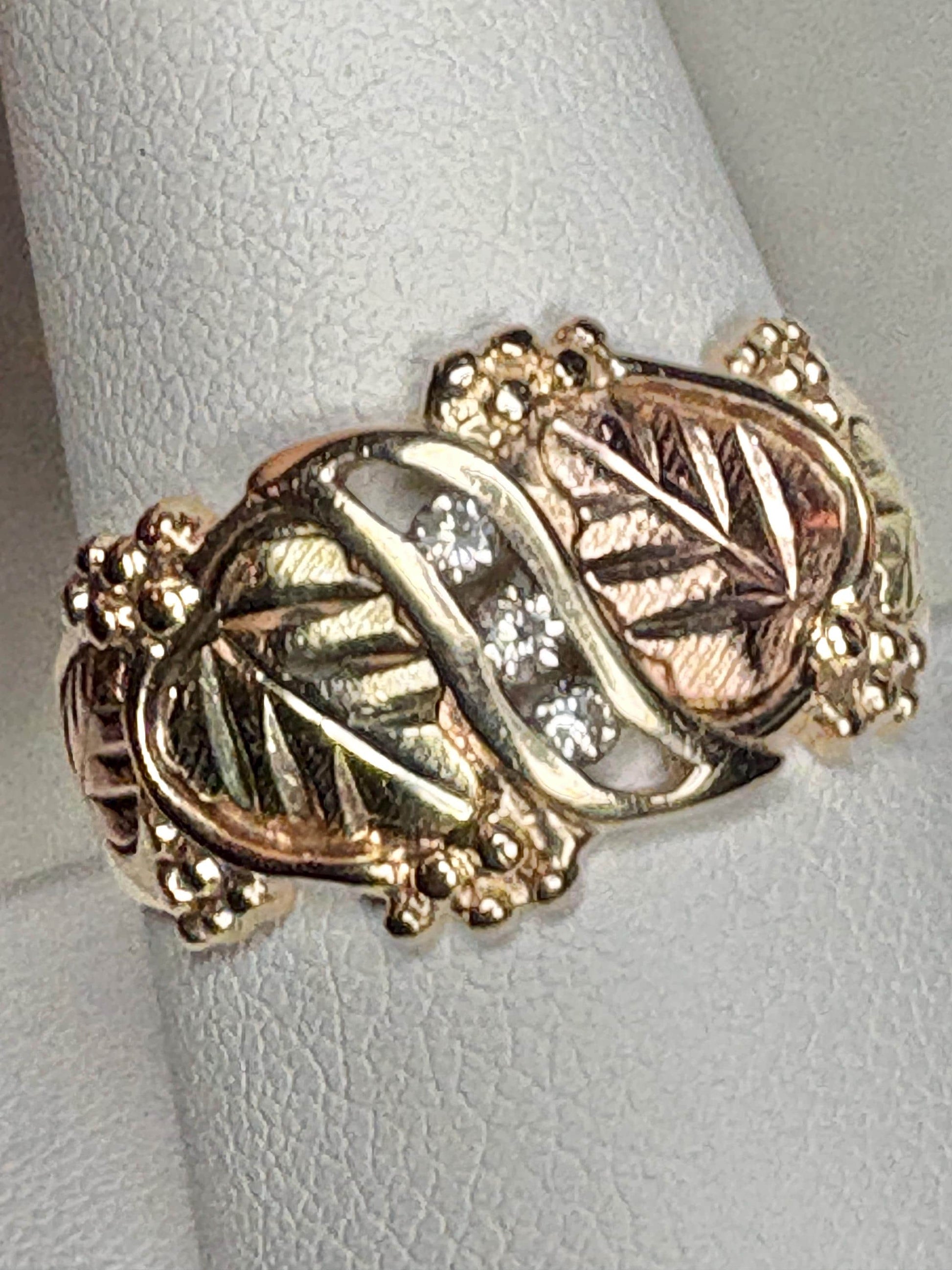 Black Hills Gold ring with three diamonds and tri-color gold leaves.