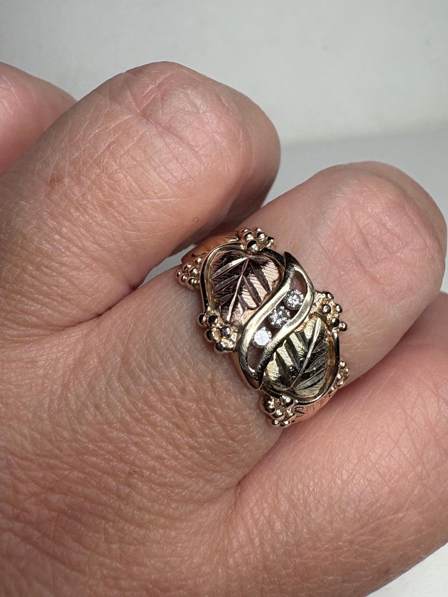 Black Hills Gold ring with diamonds and tri-color gold leaves.