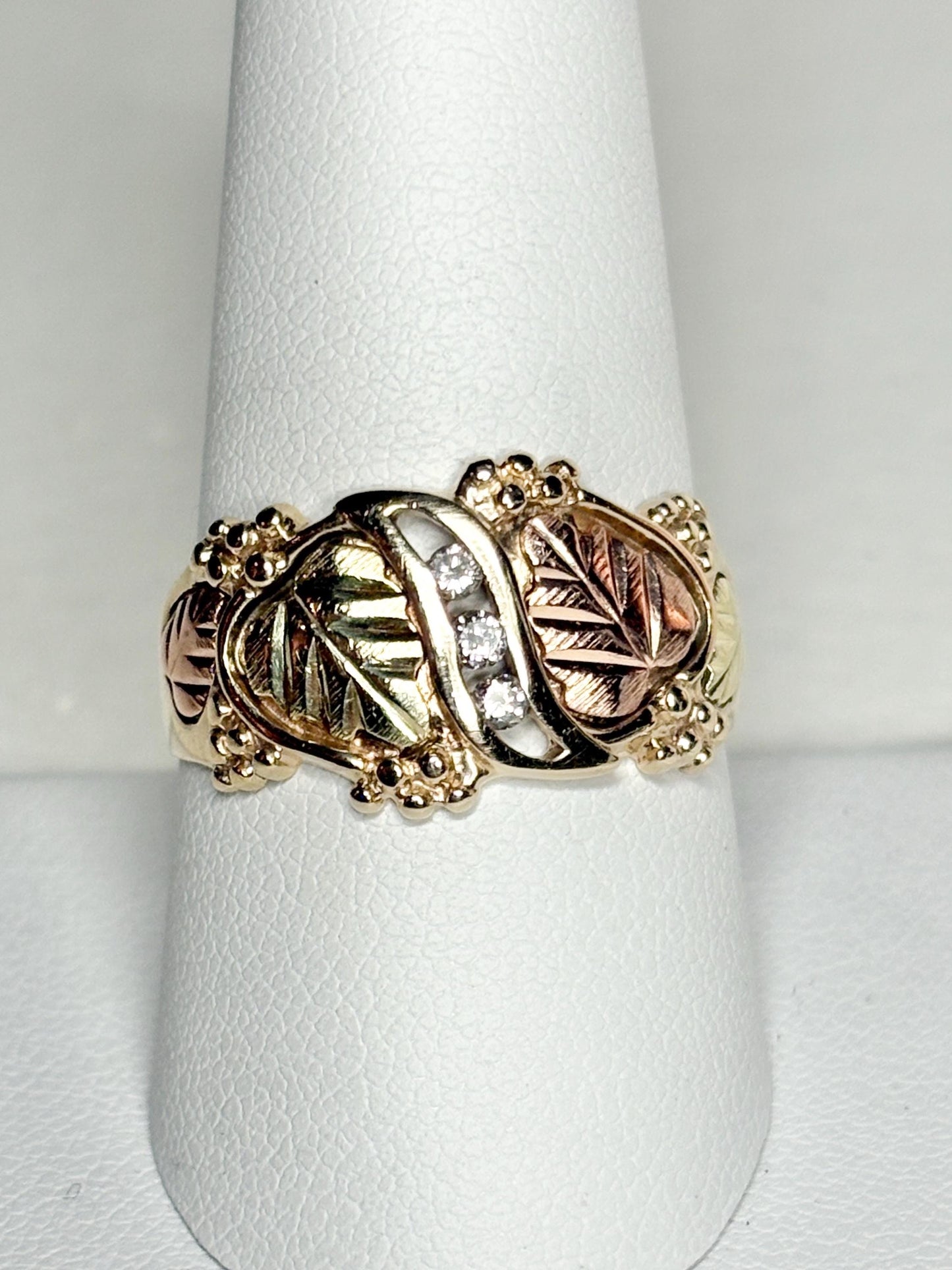 Black Hills Gold ring with three diamonds and tri-color gold leaves.
