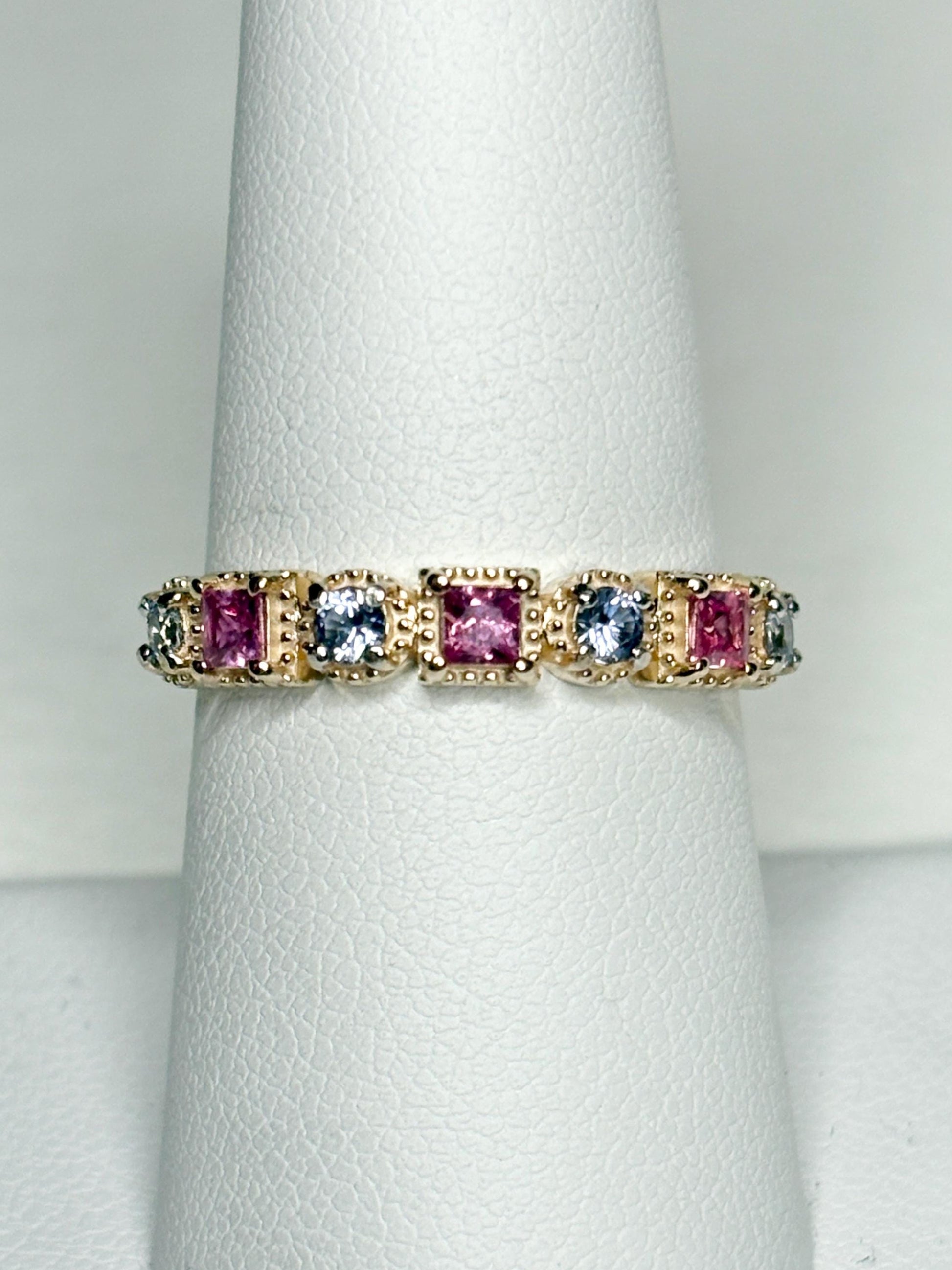 A 9k gold band ring with pink and light violetish blue square sapphires.