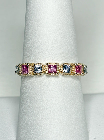 A 9k gold band ring with pink and light violetish blue square sapphires.