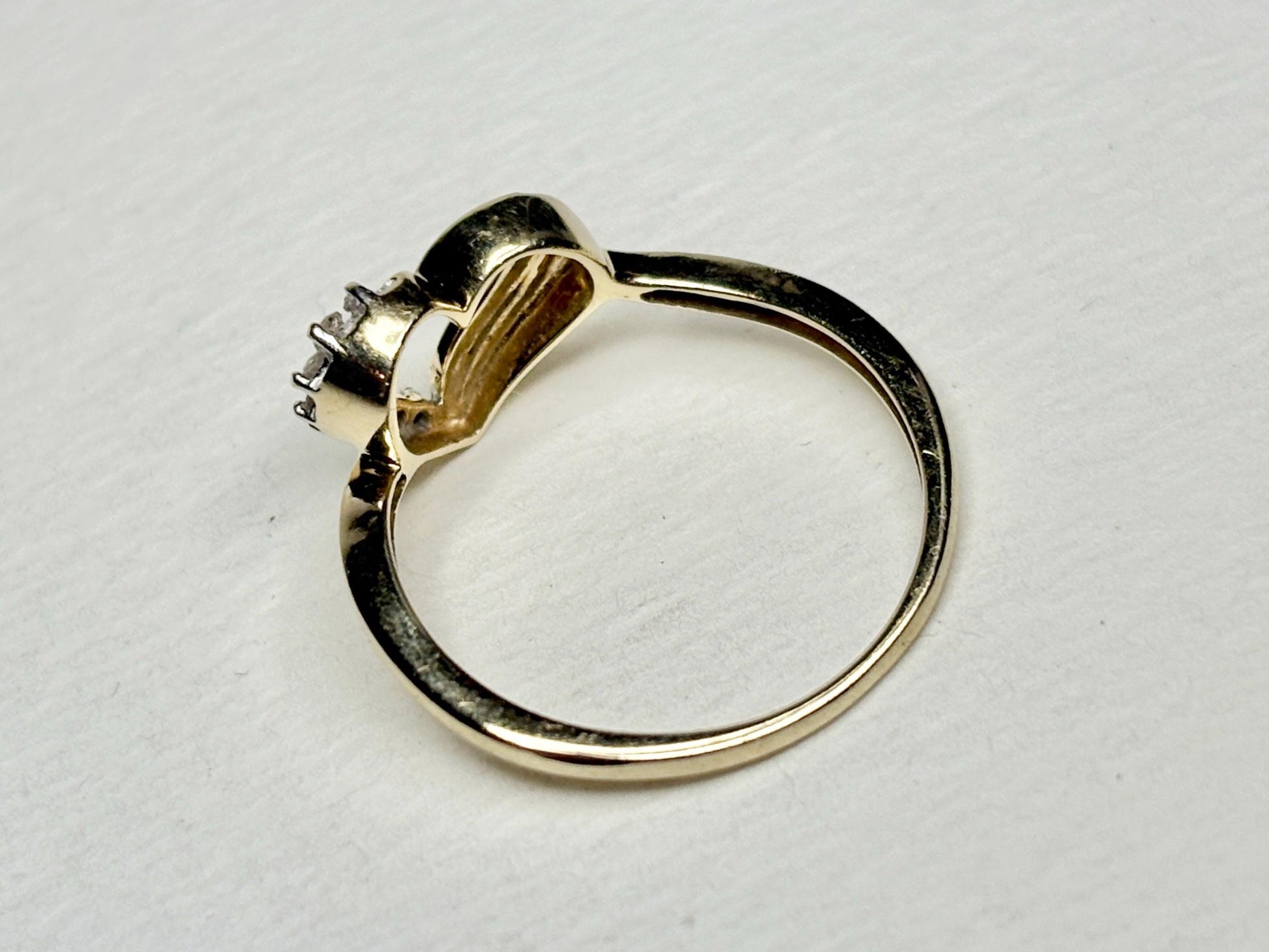 A 10k yellow gold ring with a heart design and diamonds.