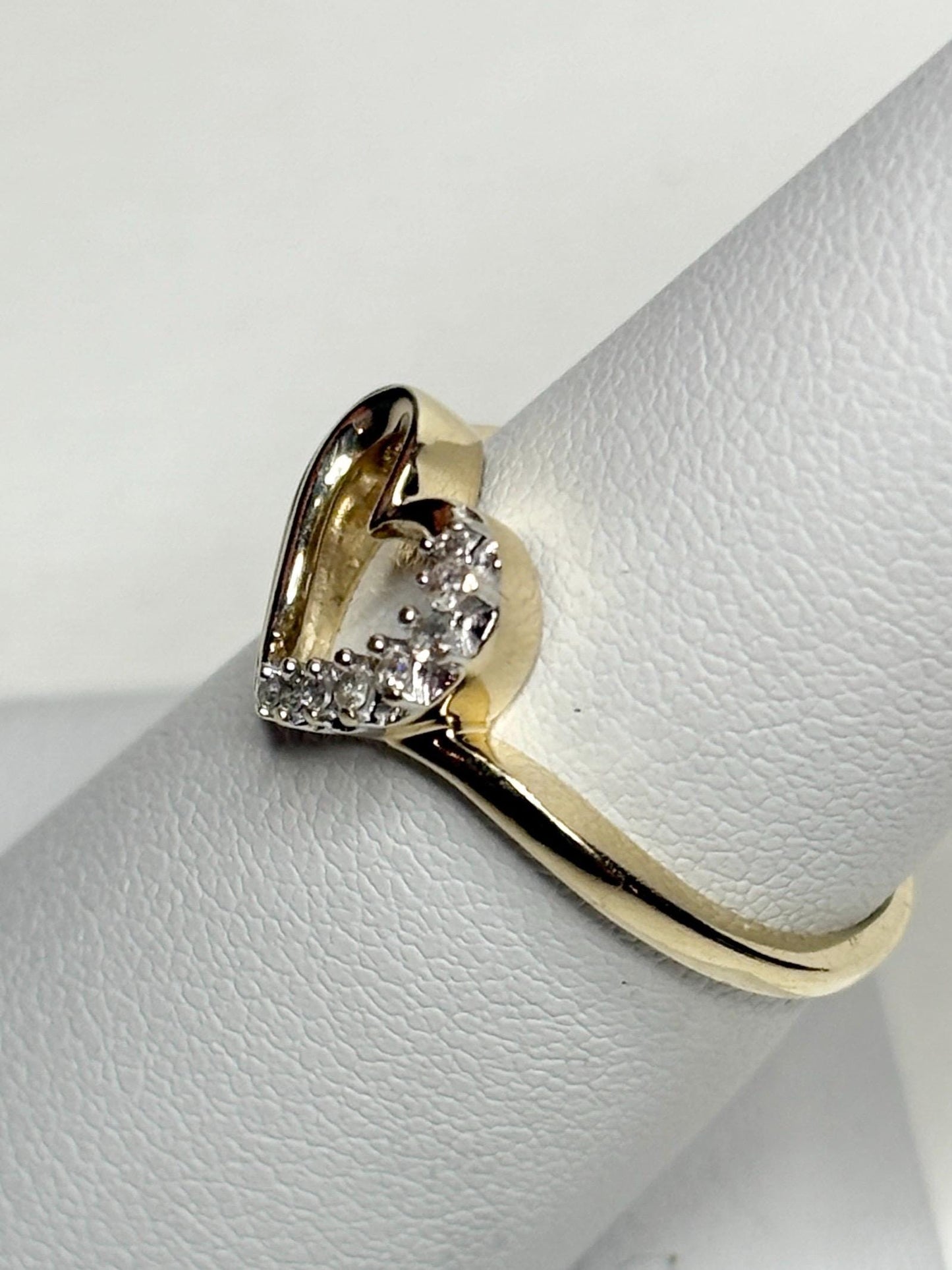 A 10k yellow gold ring with a heart-shaped diamond cluster.