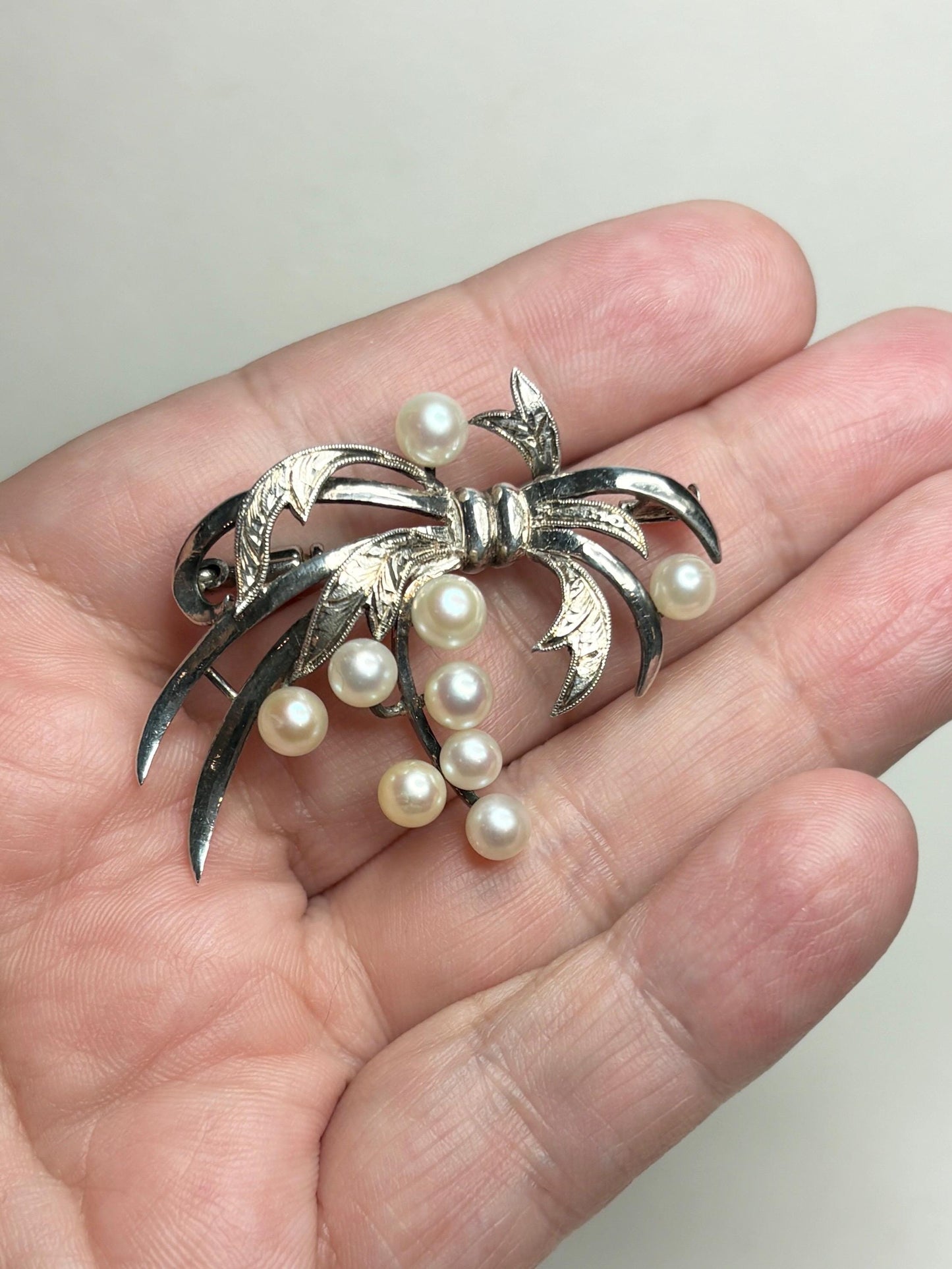 Vintage sterling silver bow brooch with 9 Akoya cultured pearls.