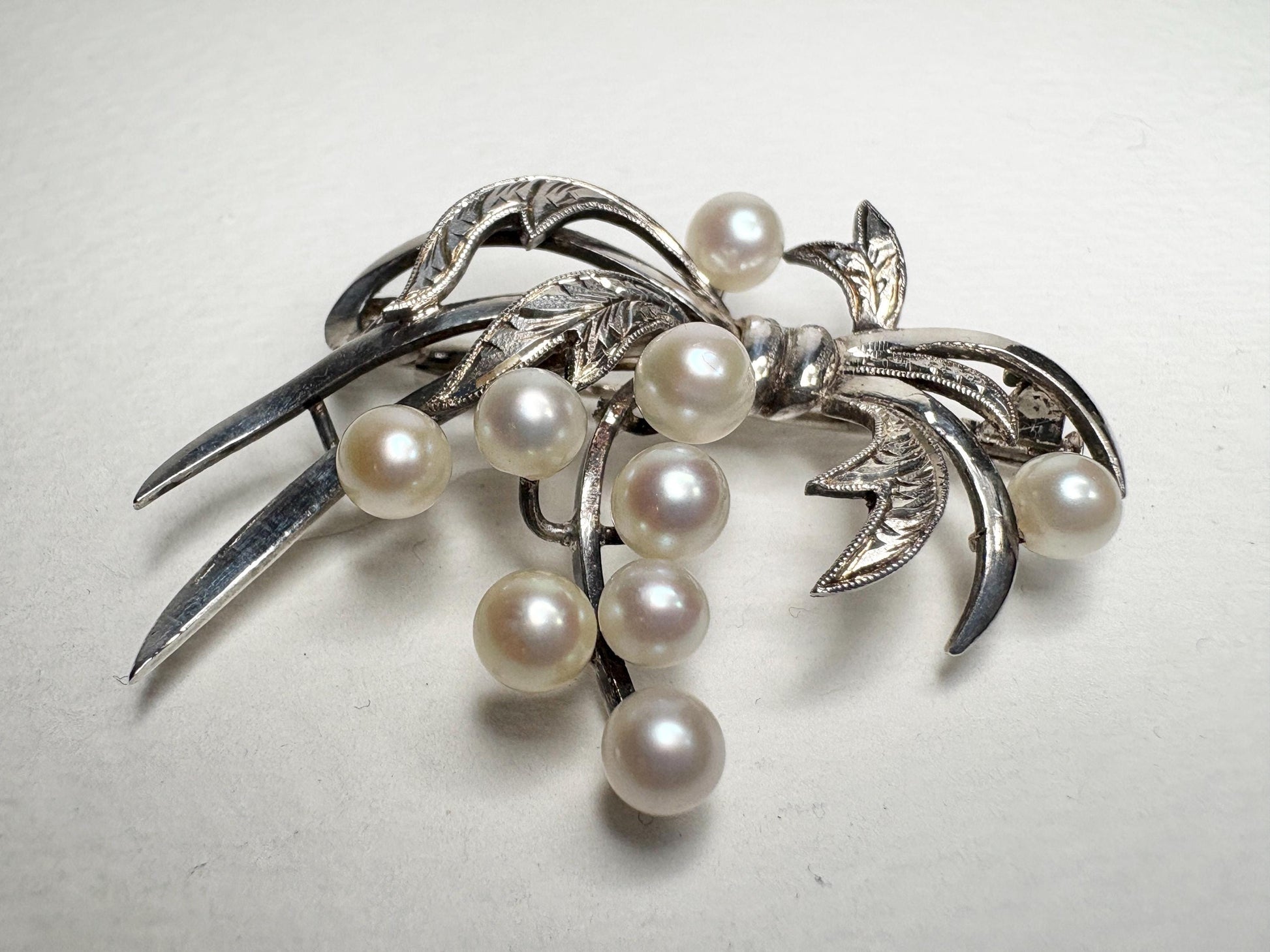 Vintage sterling silver bow brooch with nine Akoya cultured pearls.