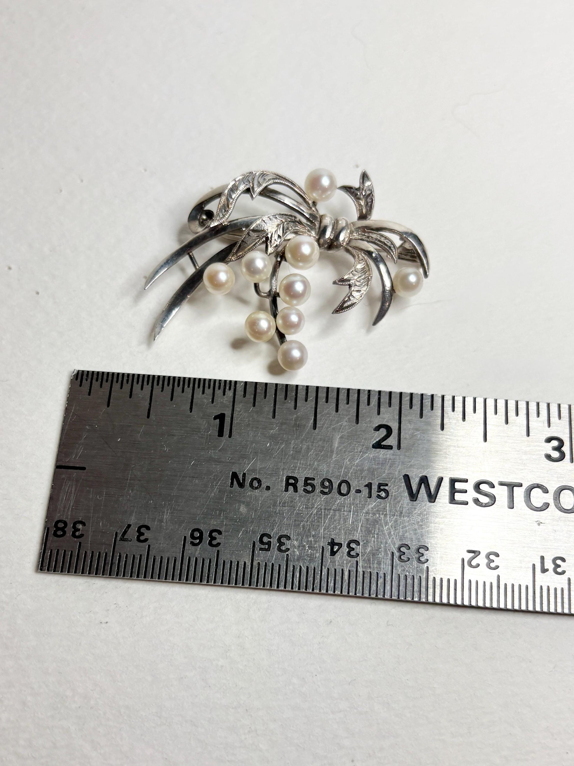 Vintage sterling silver bow brooch with nine Akoya cultured pearls.