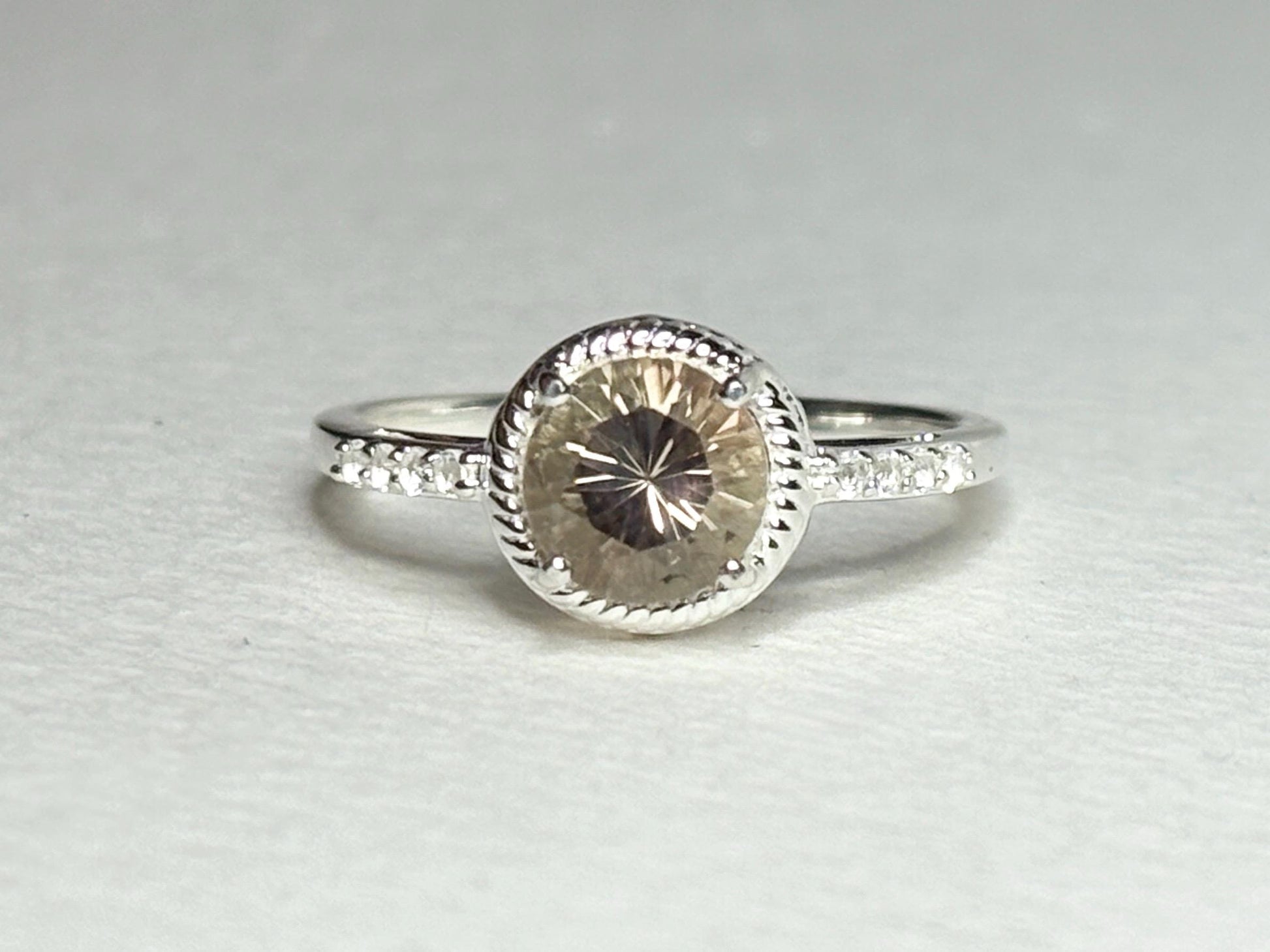 Sterling silver ring with a peach Oregon sunstone and white topaz accents.