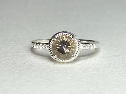 Sterling silver ring with a peach Oregon sunstone and white topaz accents.