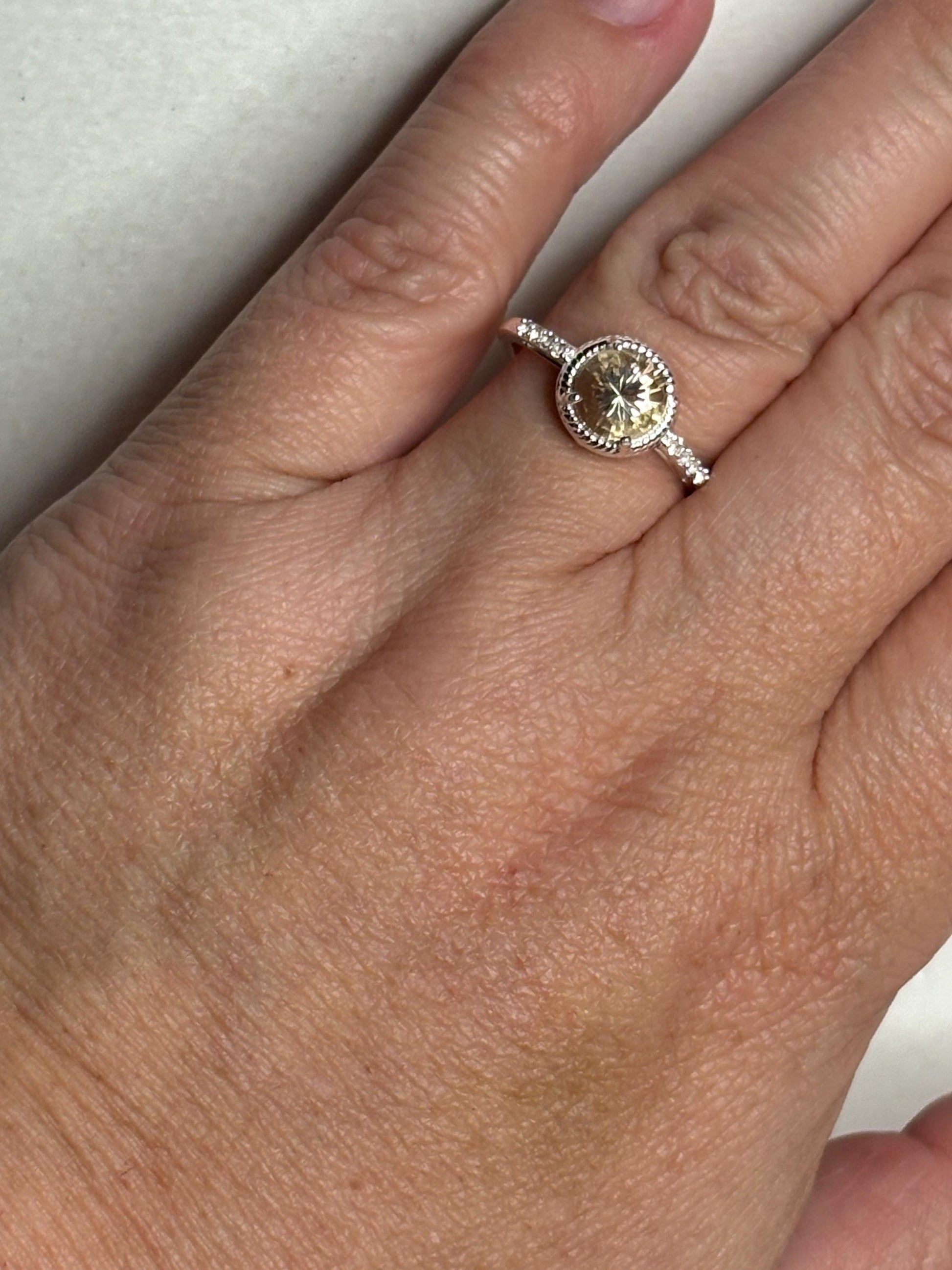 Sterling silver ring with a round Oregon sunstone and white topaz accents.