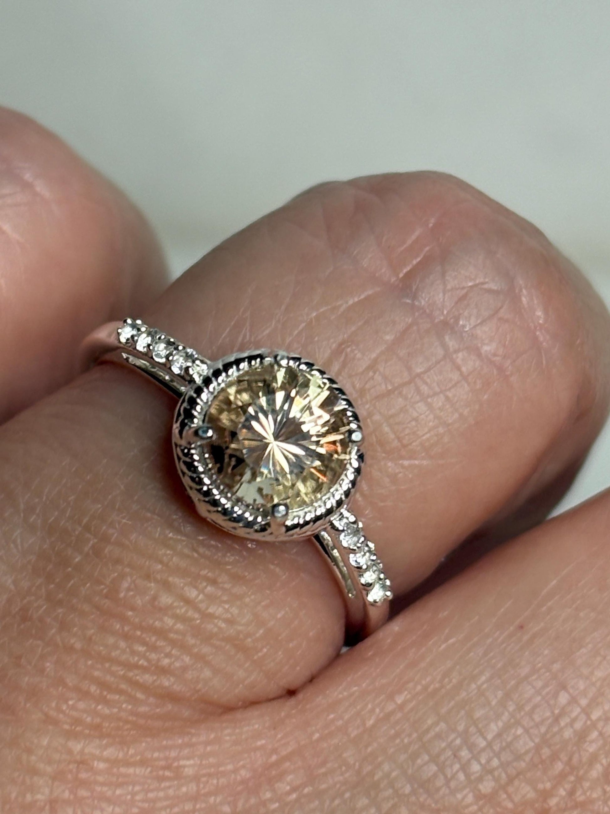 Sterling silver ring with a round Oregon sunstone and white topaz accents.