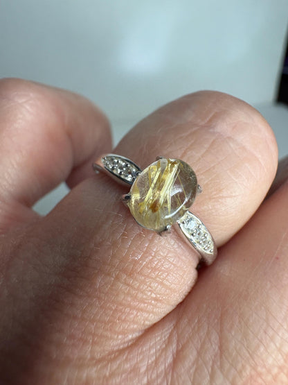 Sterling silver ring with oval rutilated quartz and zircon accents.