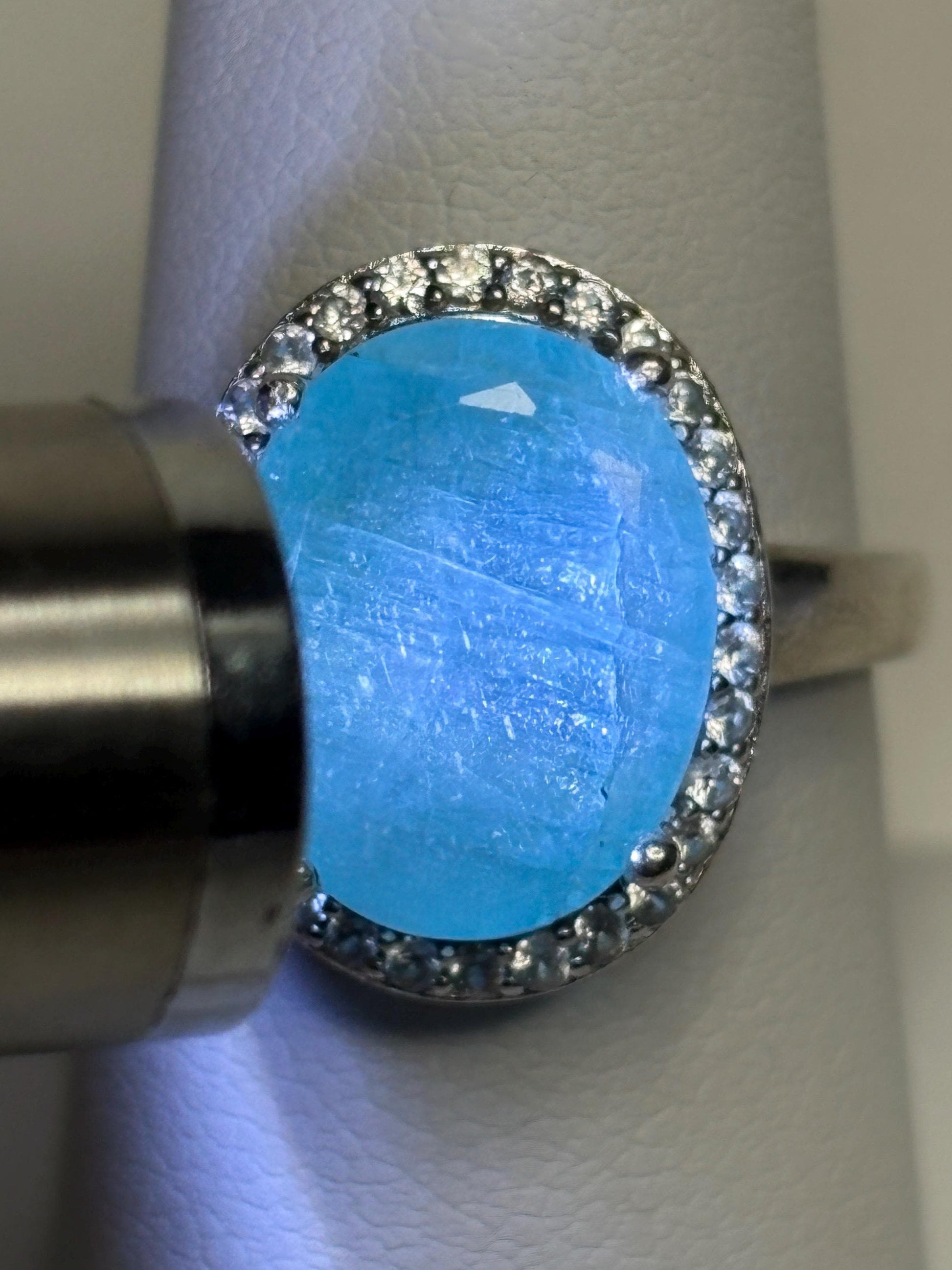 Sterling silver ring with a large oval grandidierite and zircon halo.