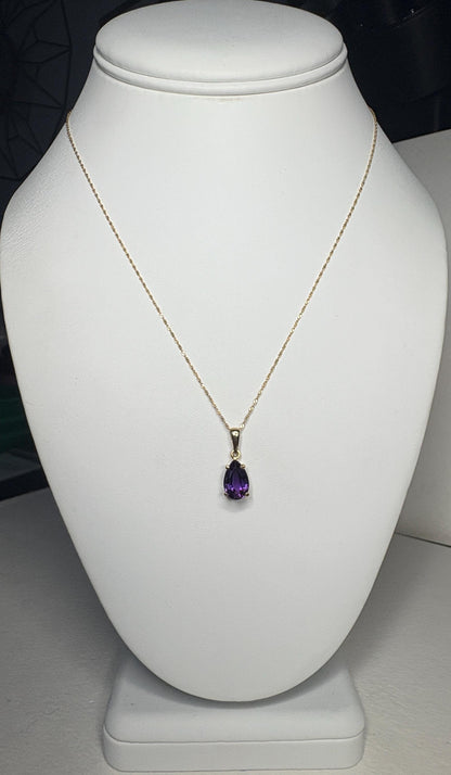 A 14k gold necklace with a pear-shaped amethyst pendant.