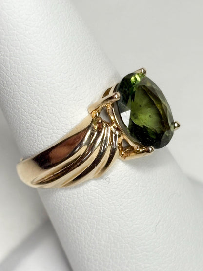 14k gold ring with an oval faceted moldavite gemstone.