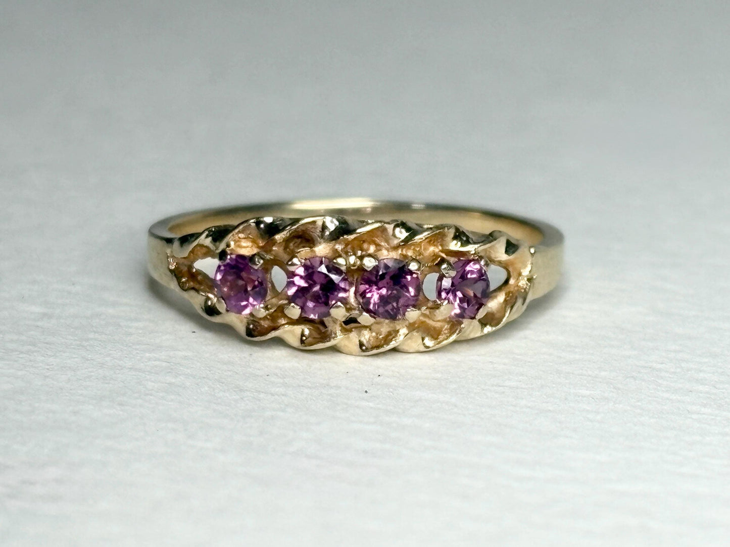 A 10k gold ring with five rhodolite garnets set in a rope band.