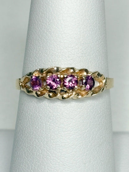 A 10k gold ring with five rhodolite garnets and a rope band.