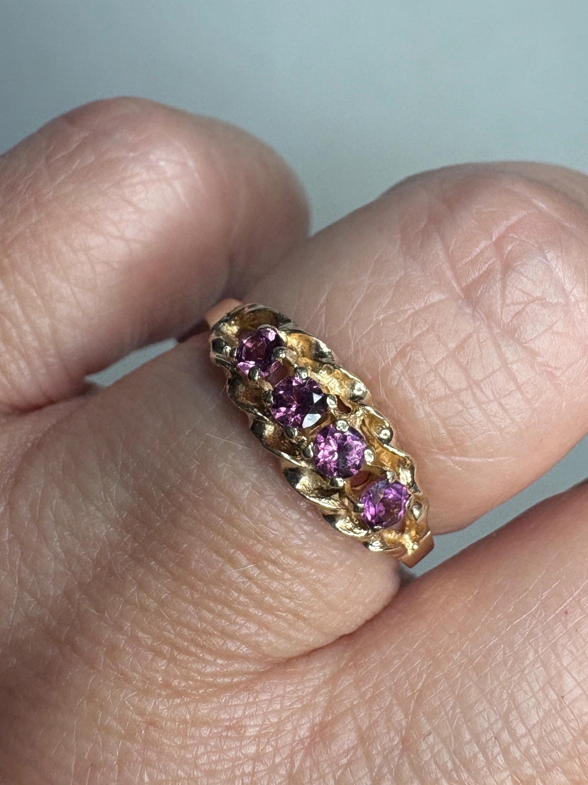 A 10k gold rope band ring with four rhodolite garnets.