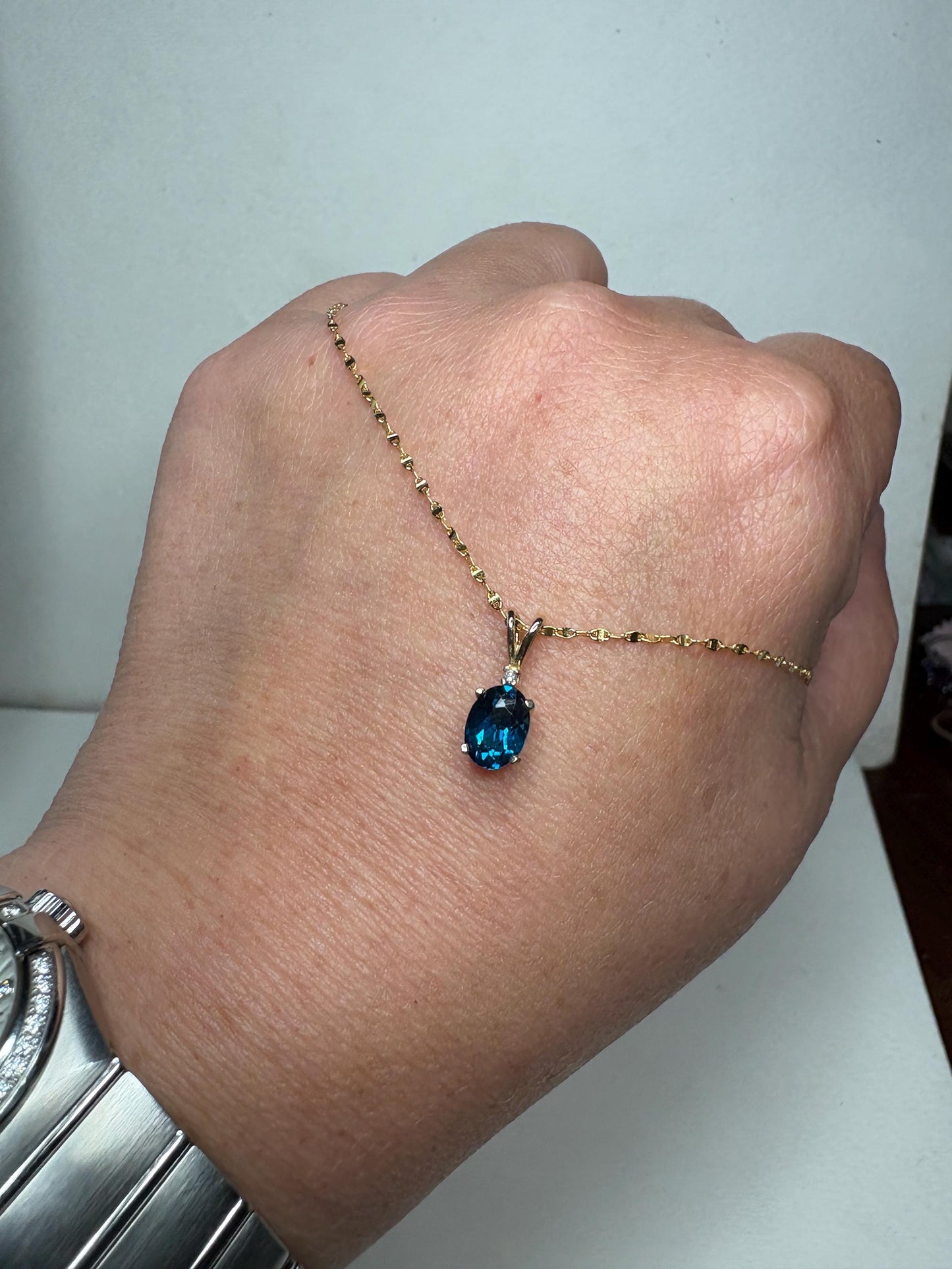 14k gold necklace with oval London blue topaz and diamond accent.