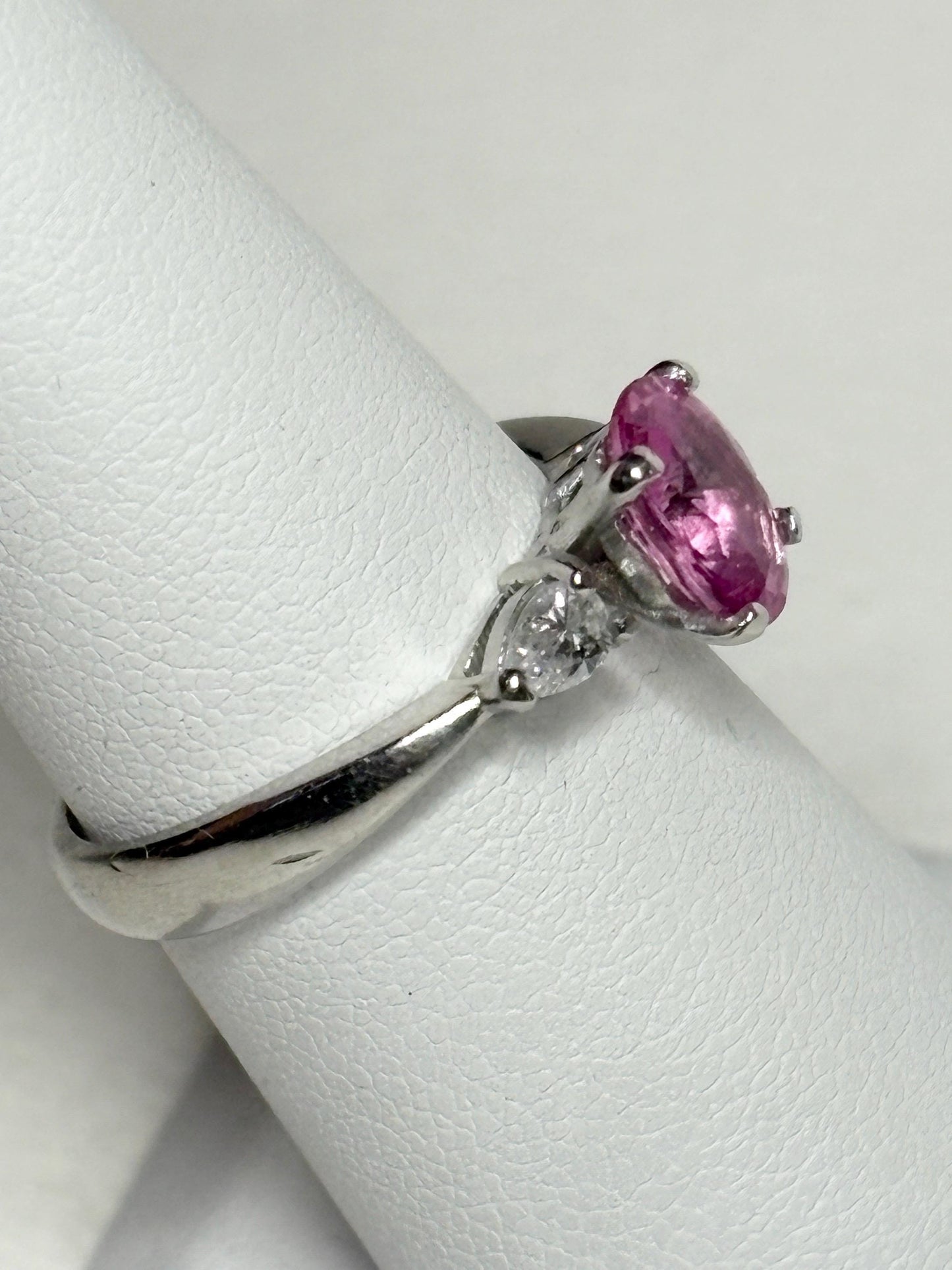 Platinum ring with oval pink sapphire and pear diamonds.