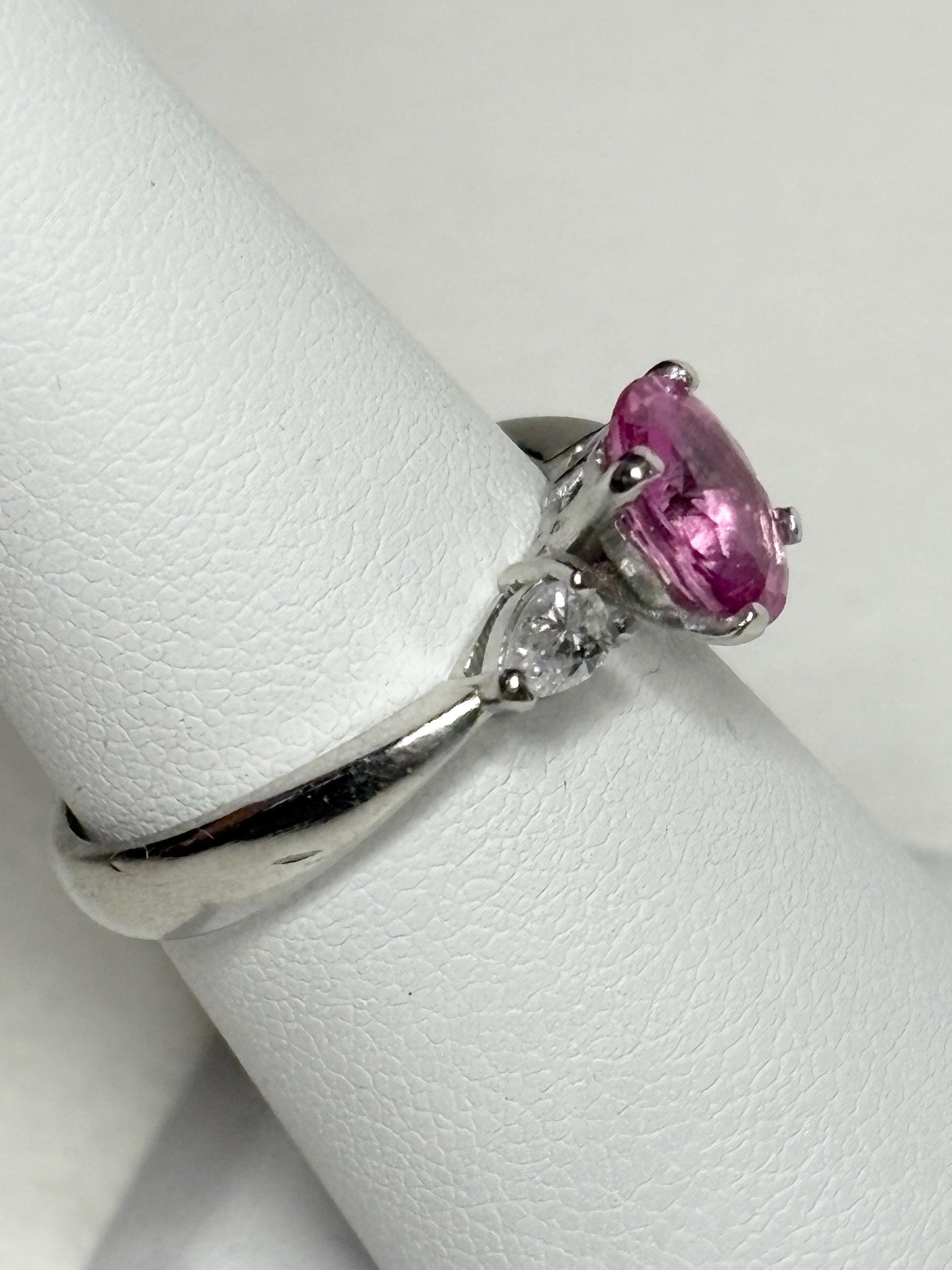 Platinum ring with oval pink sapphire and pear diamonds.