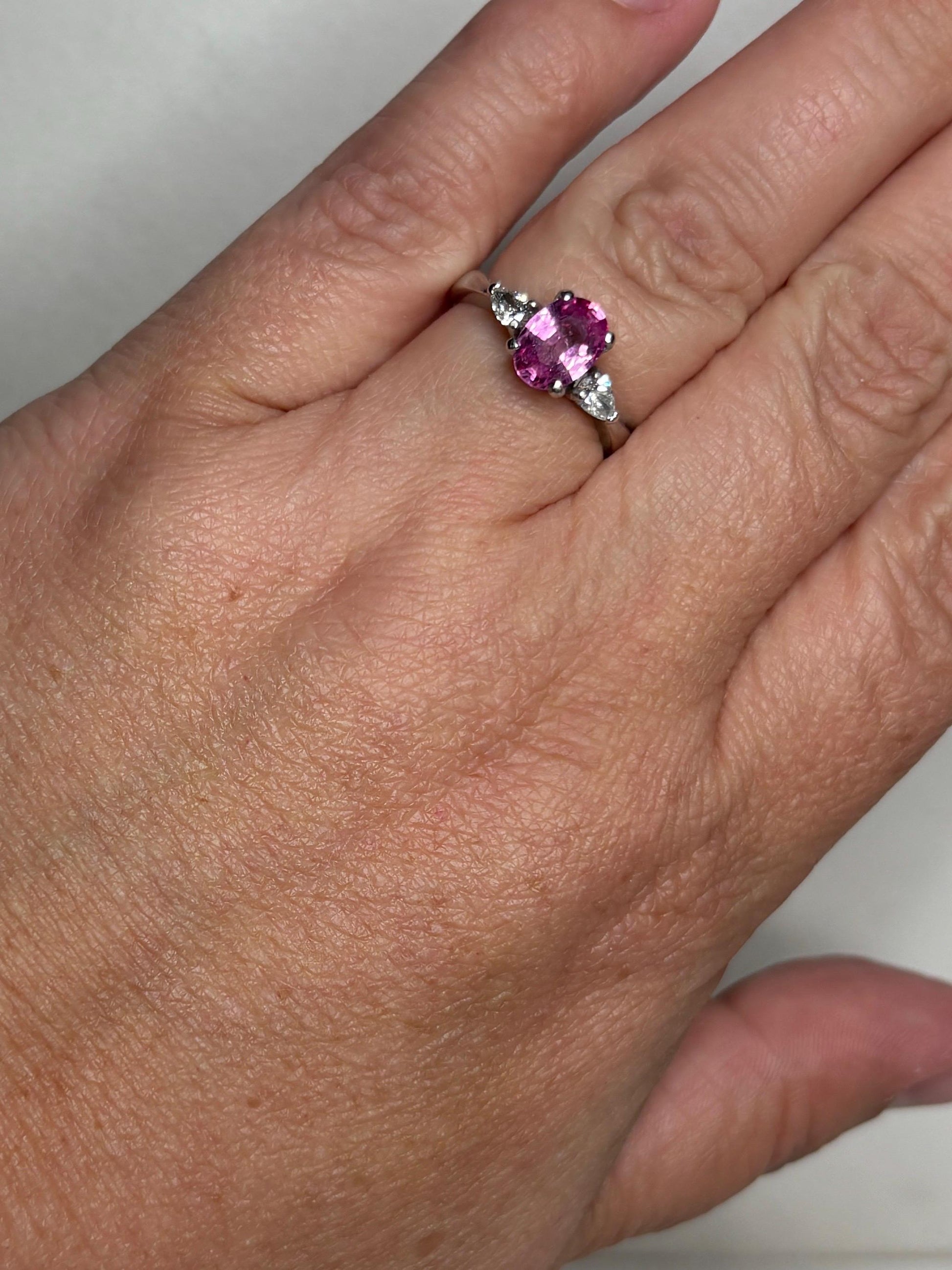 Platinum ring with oval pink sapphire and pear diamonds.