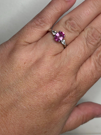 Platinum ring with oval pink sapphire and pear diamonds.