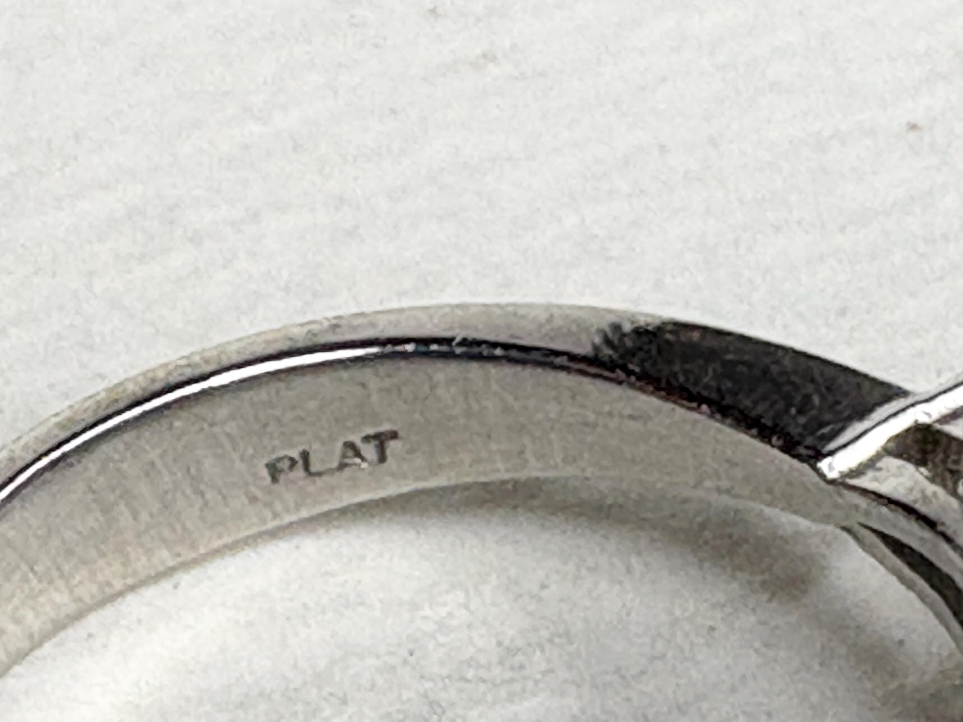 Platinum ring with "PLAT" stamp and a pink sapphire.