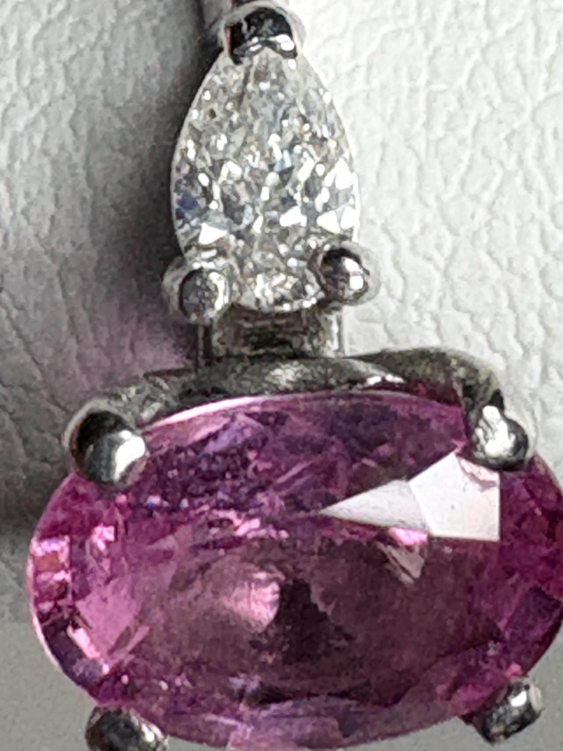Platinum ring with oval pink sapphire and pear diamonds.