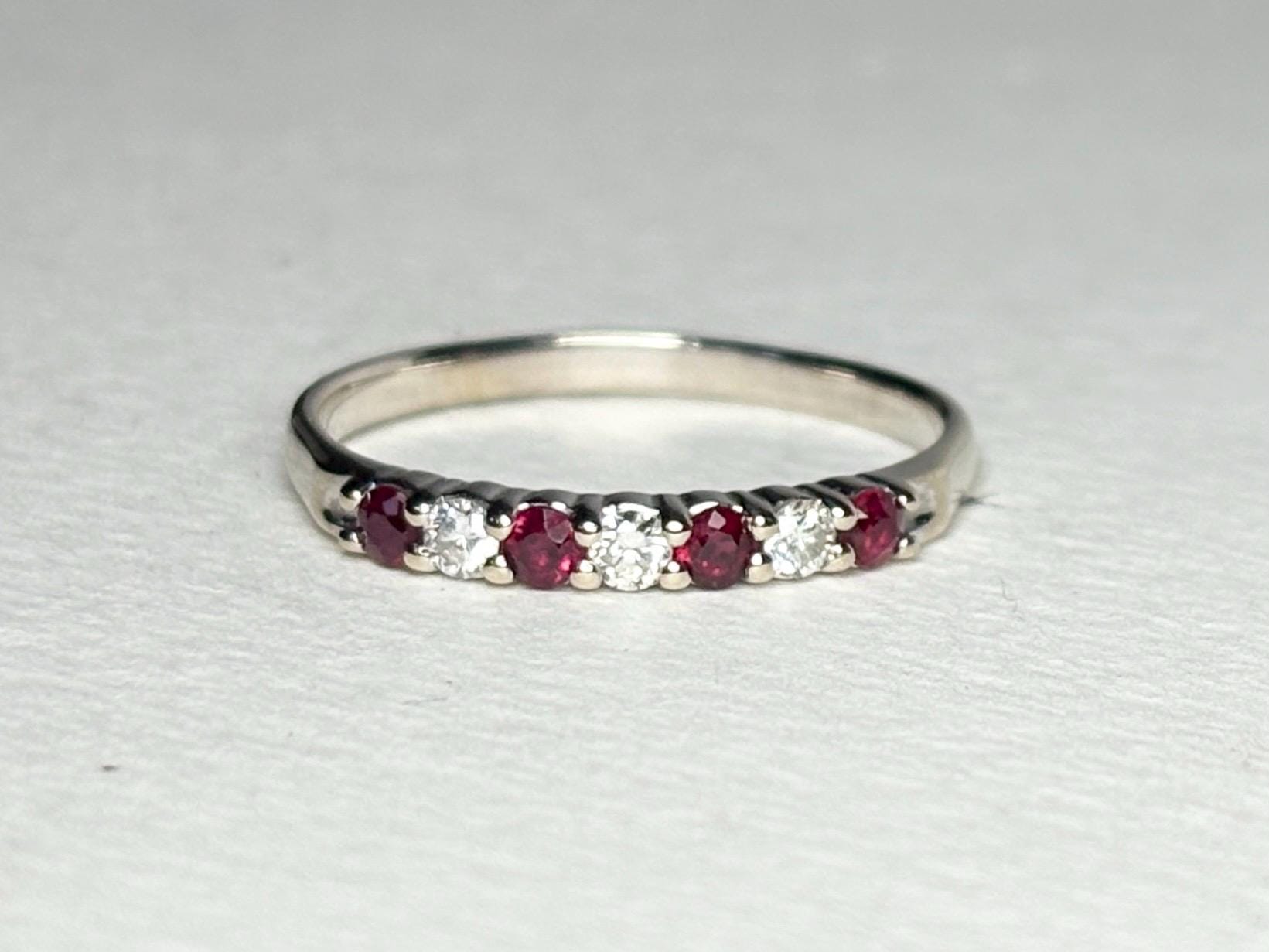 A white gold band ring with alternating rubies and diamonds.