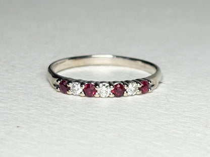 A white gold band ring with alternating rubies and diamonds.