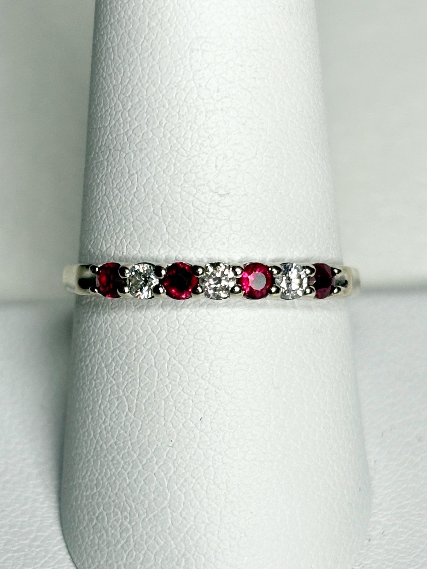 A white gold band ring with alternating rubies and diamonds.
