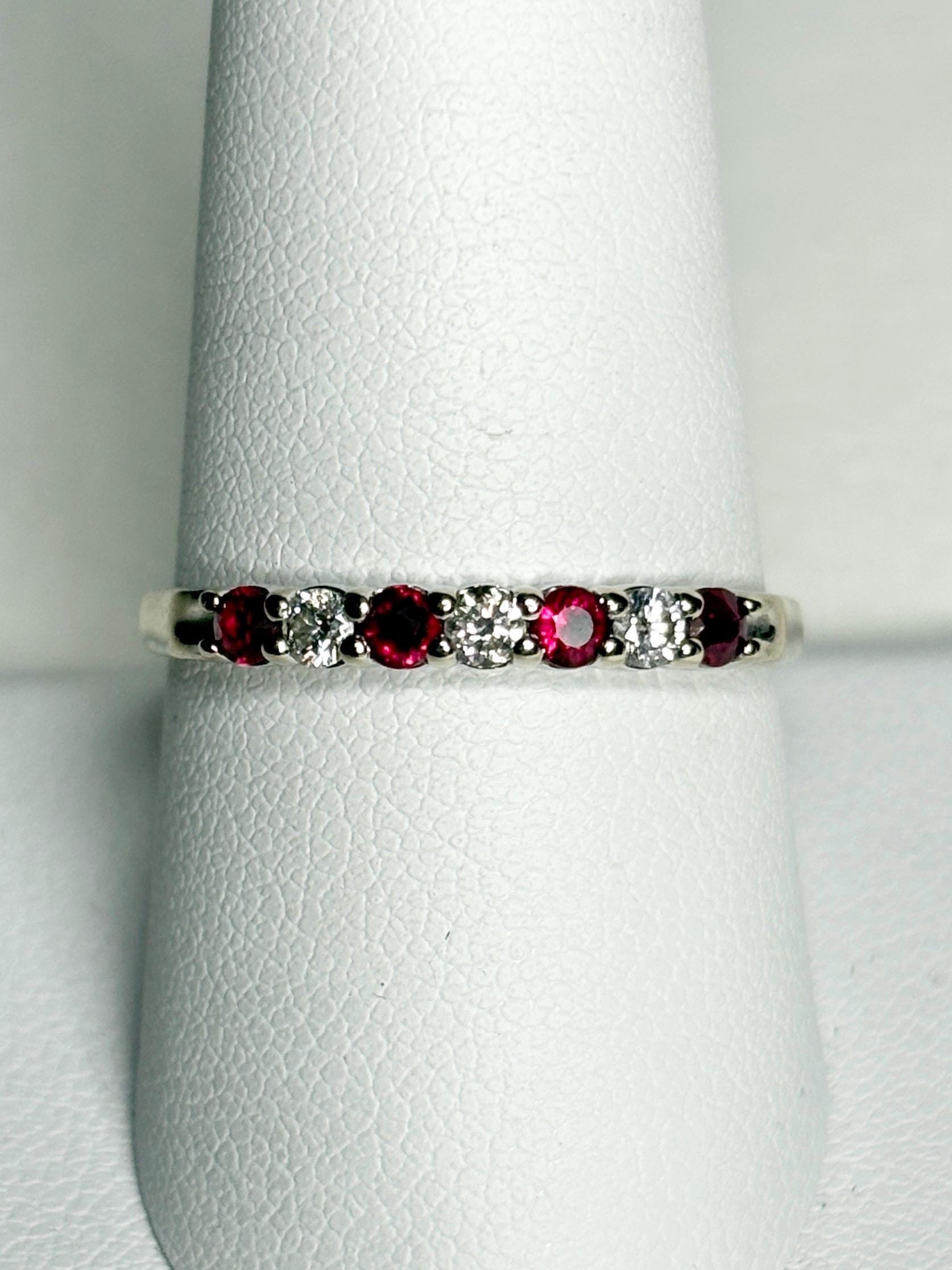 A white gold band ring with alternating rubies and diamonds.