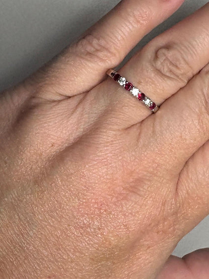 A 14k white gold band ring with alternating rubies and diamonds.
