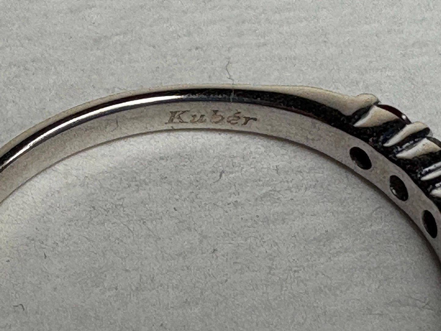 A white gold band ring with the engraving "Kuber".