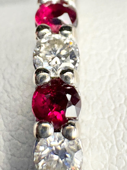 A white gold band ring with alternating rubies and diamonds.
