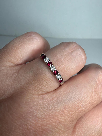 A 14k white gold band ring with alternating rubies and diamonds.